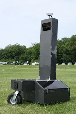 Phoebeter, large, dark-gray robot with tall sensor system sits in grass