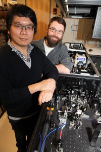 Graduate student Desmond Toa (left) and Jacob Dean, a postdoctoral research associate and lecturer in chemistry with the laser set-up, Credit: C. Todd Reichart